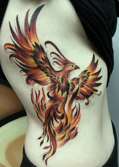 Tatuaje de ave fenix en costado de mujer